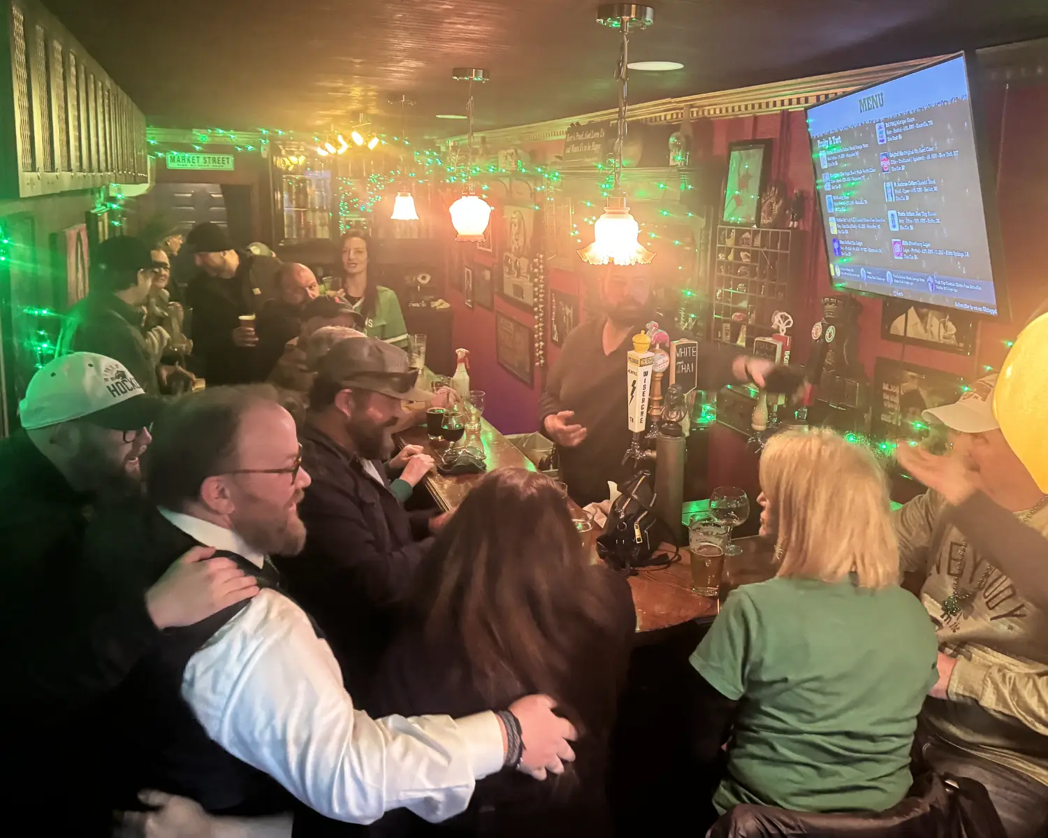 A lively crowd gathered around the bar on a busy night