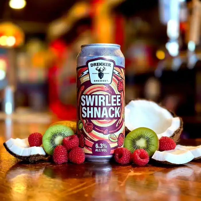 A beer served with fresh fruit garnish on the bar